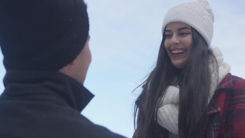 A woman smiles and laughs with a man