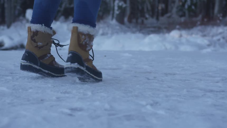 A woman turns in circles on the snow covered ground