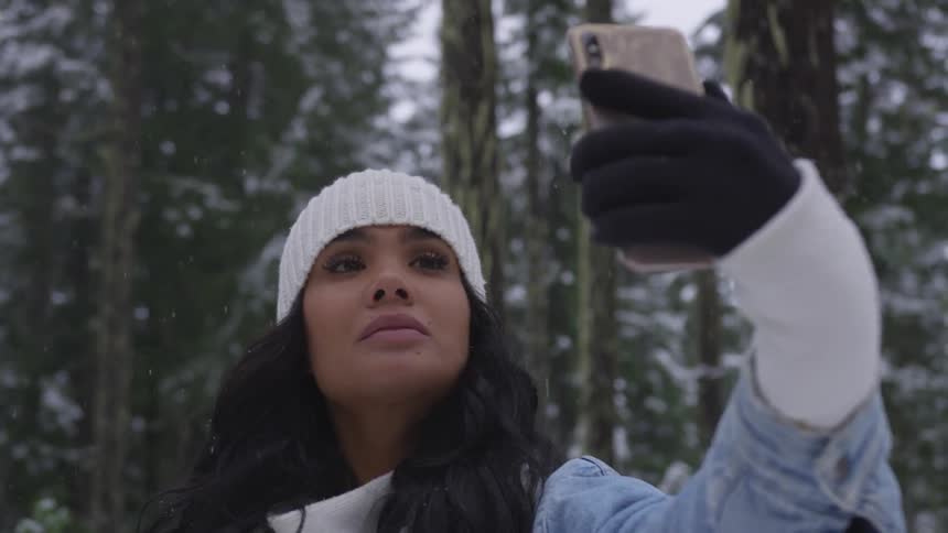 A black woman takes a selfie in the woods
