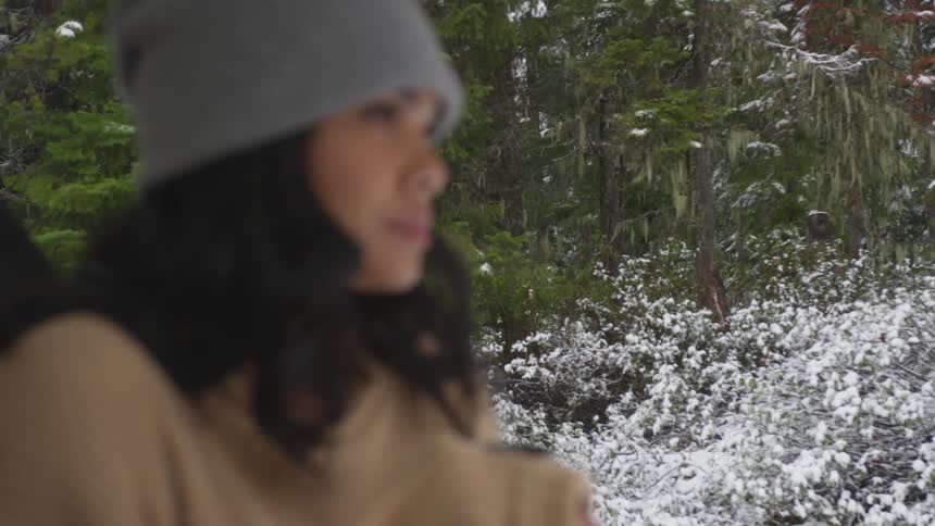 A woman is standing outside in the forest