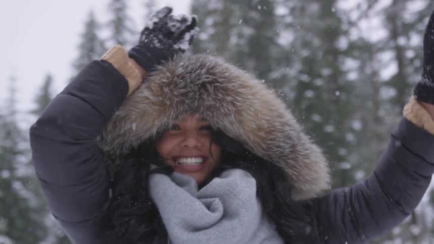 Young woman smiling while outside in the snow