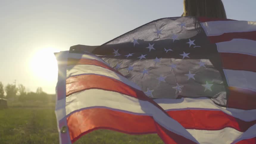 A woman holds a flag in the wind