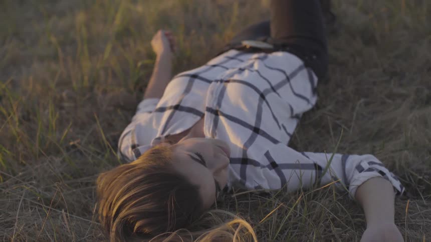 A white woman lies on the ground on her back