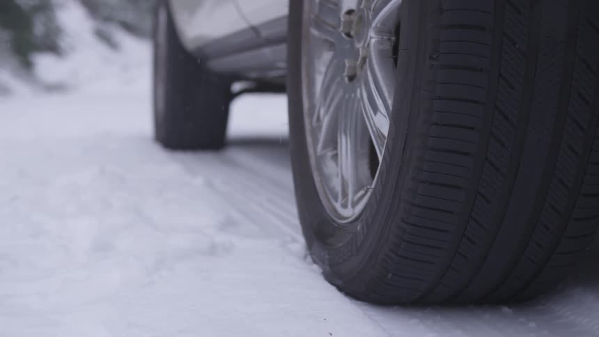 A car parked in the snow on a road