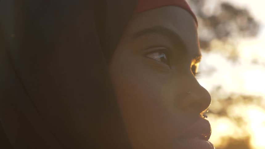 A woman is looking towards the sunset