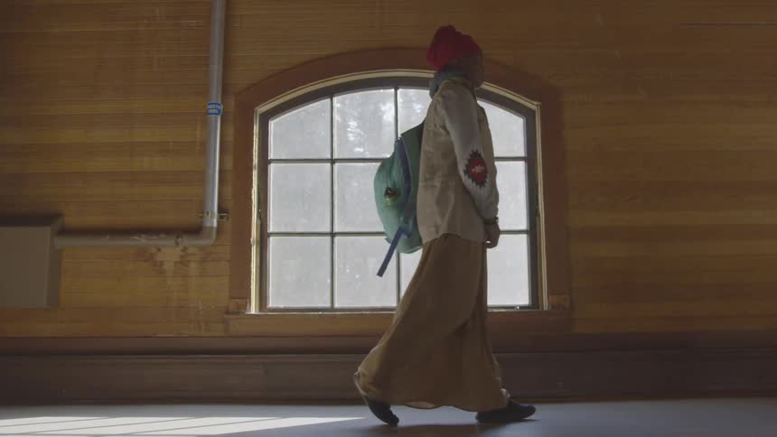 Woman with a backpack walks past a window