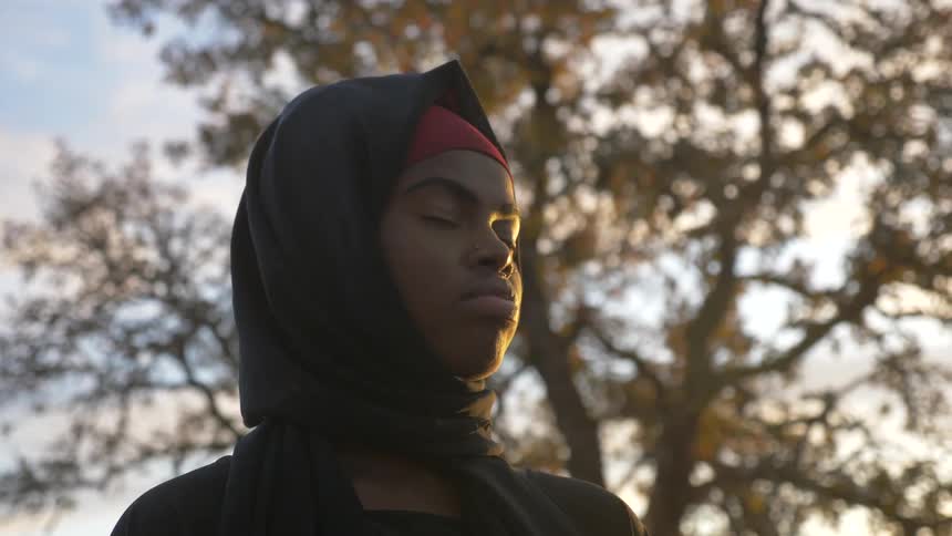 A boy stands with his eyes closed