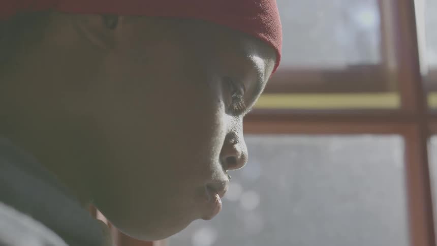 Black woman sits near a window