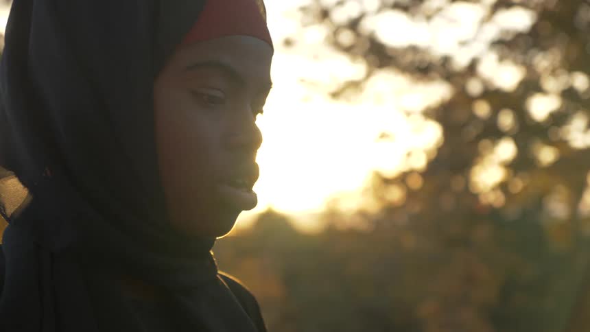 Woman praying outside at sunset