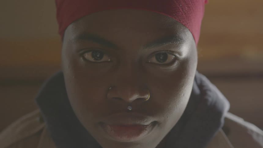 A woman with nose and medusa piercing stares into the camera