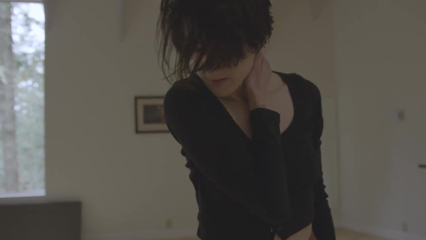 Short hair woman dances indoors during daylight
