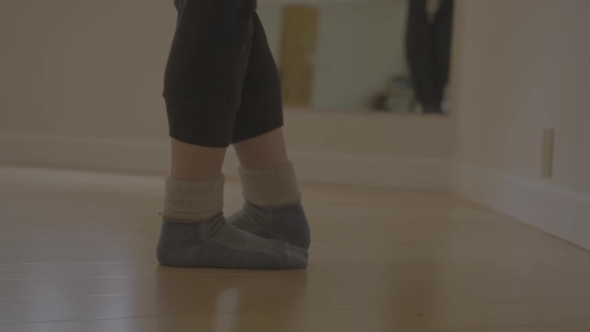 A person dances in their socks