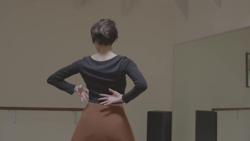 A woman spins and dances in a studio