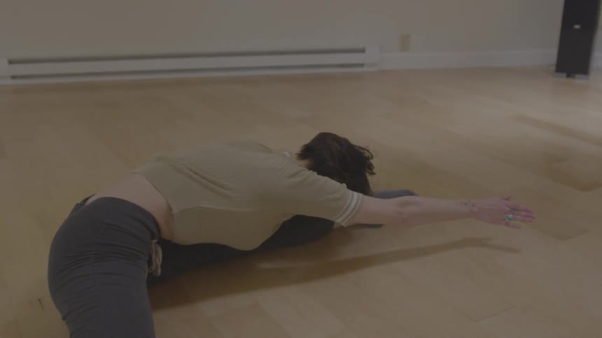 A woman is stretching indoors