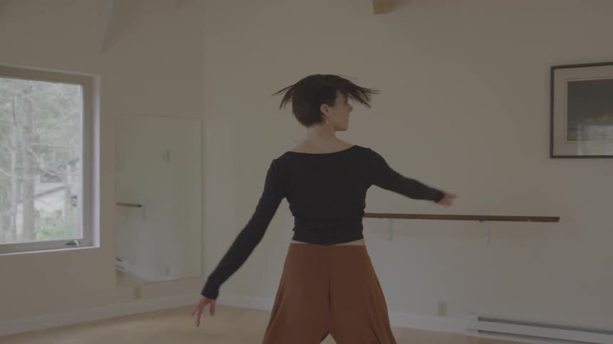 A woman spins and dances in an empty dance room