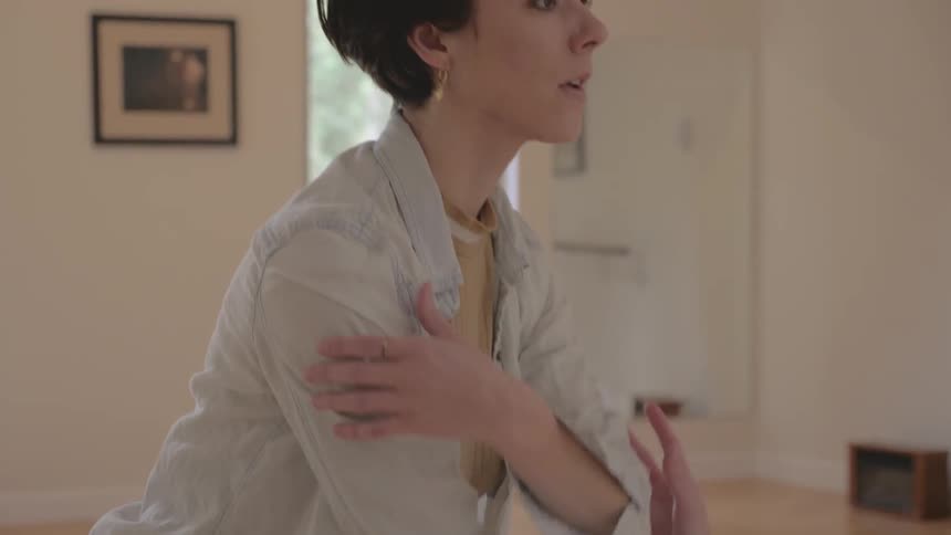 A woman practices modern ballet steps in a studio