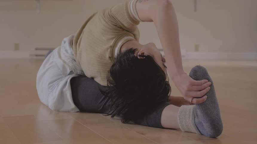 A female doing the splits and stretching on the floor