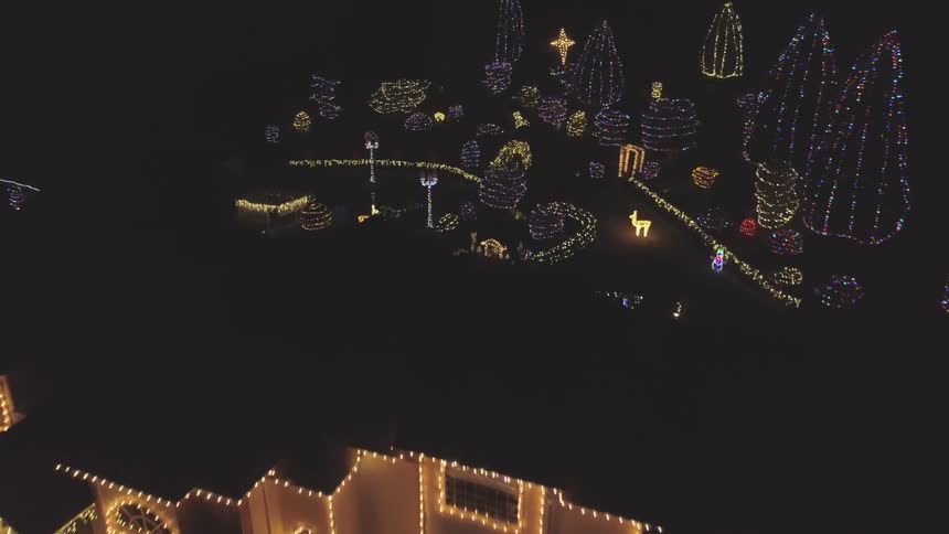 A large house and backyard covered in christmas lights
