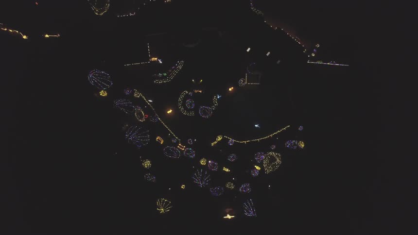 An aerial view of designs of lights in the shape of clamshells on the ground as seen in the night