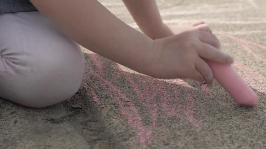 A child drawing on a road with chalk