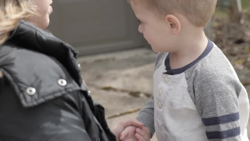 A mother cleans the right hand of a young child and they talk and later there's an understanding kiss