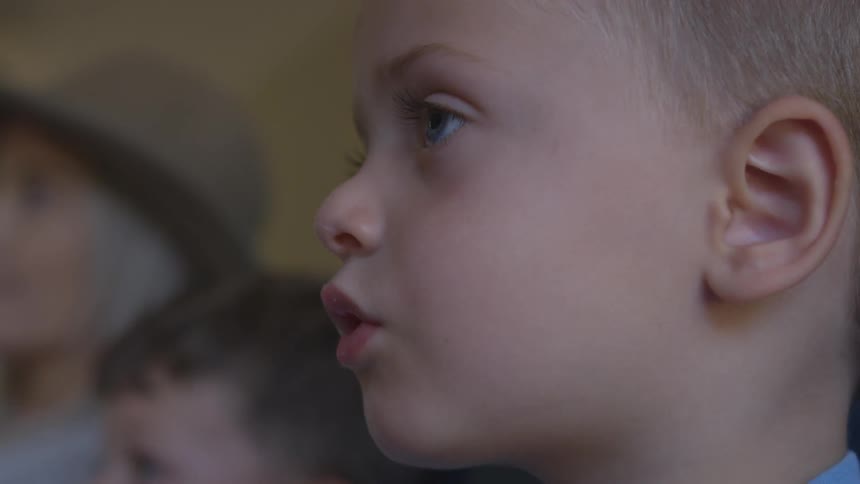 Small boy puts a piece of food in his mouth and starts chewing