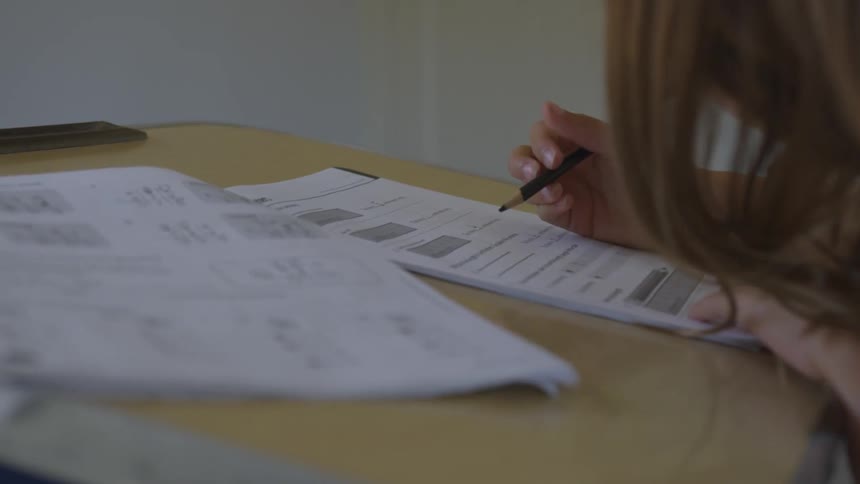 A young girl working on homework at a desk