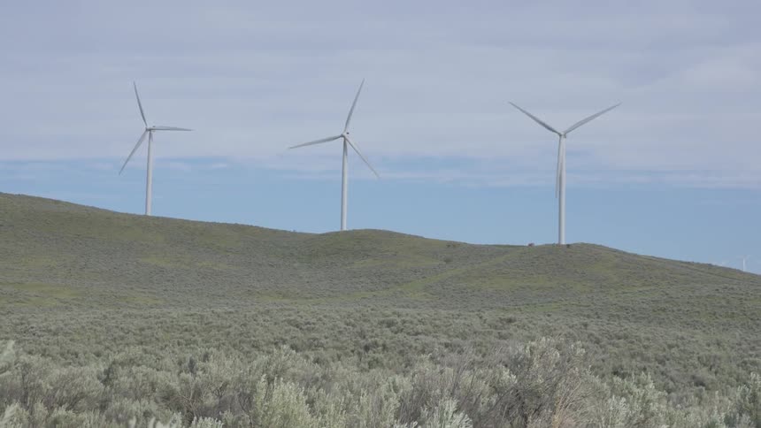 Wind turbines turn on top of a hill