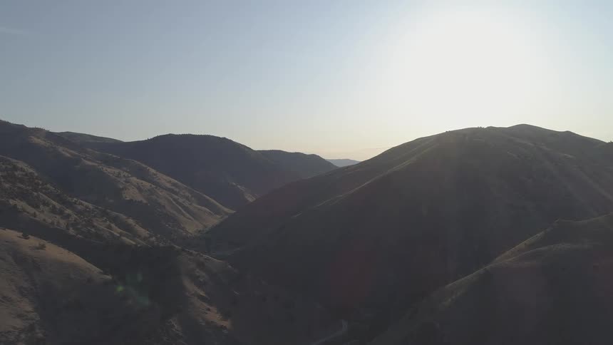 Rolling brown hills with the sun shining down