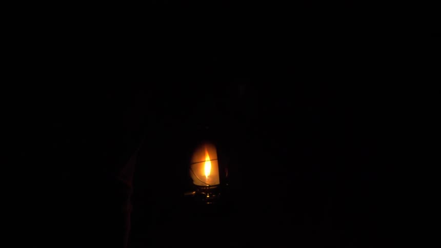 A flame glows in the darkness