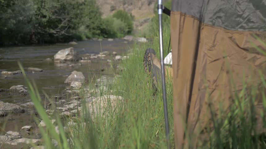 Someone relaxing in a tent by the river