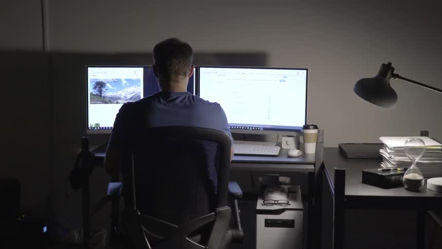 A person works in front of two monitors