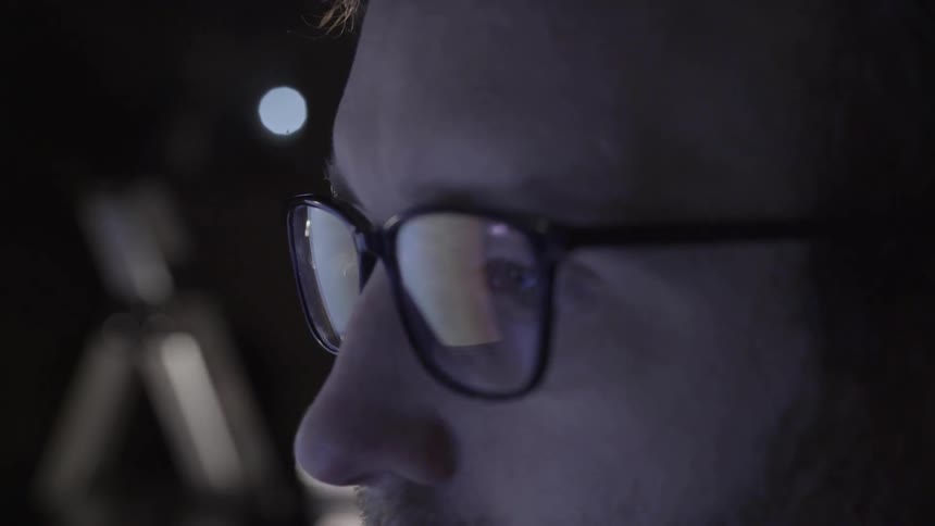Man reads screens in dark room