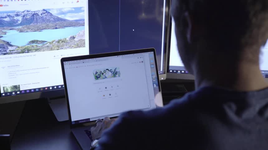 Man studies laptop display at desk