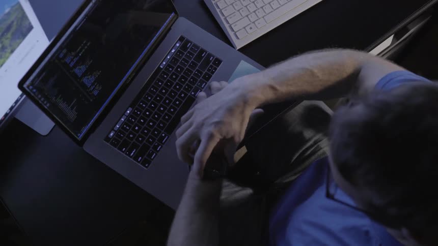 Man sitting at a desk working on a laptop