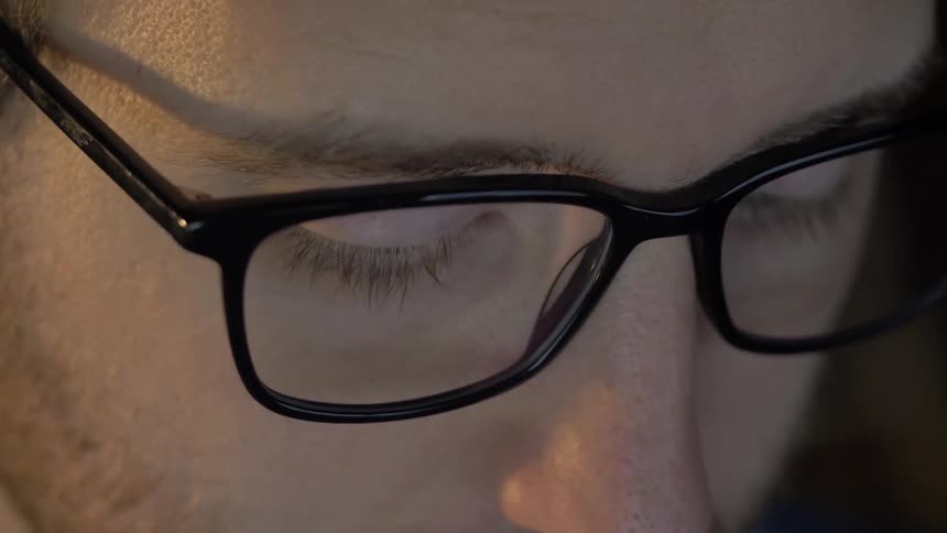 Close up of man wearing glasses looking up and down
