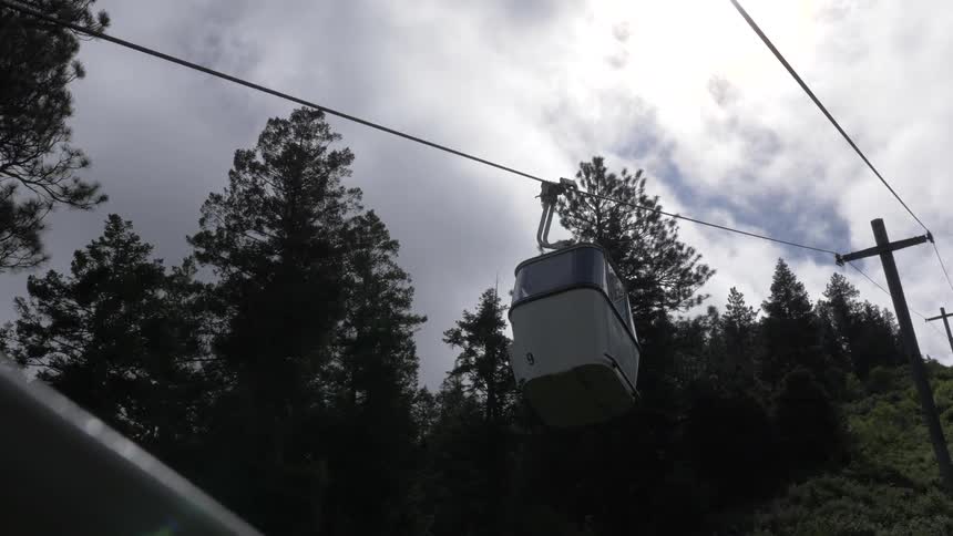 Overhead cable car travels down mountain