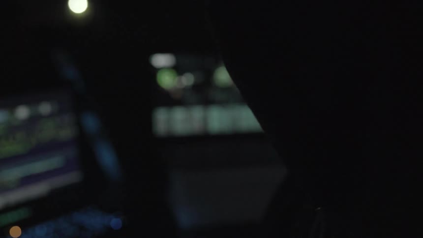 Man looks over displays in dark room