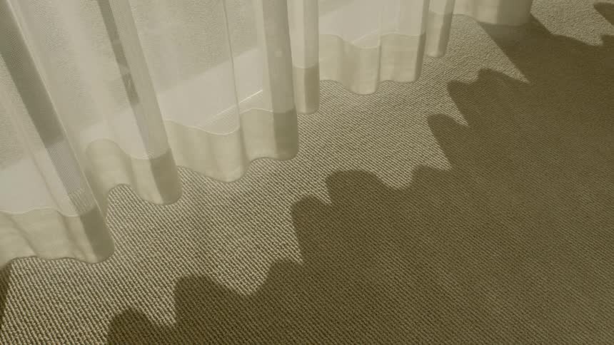 The camera looks at shadows cast by drapes