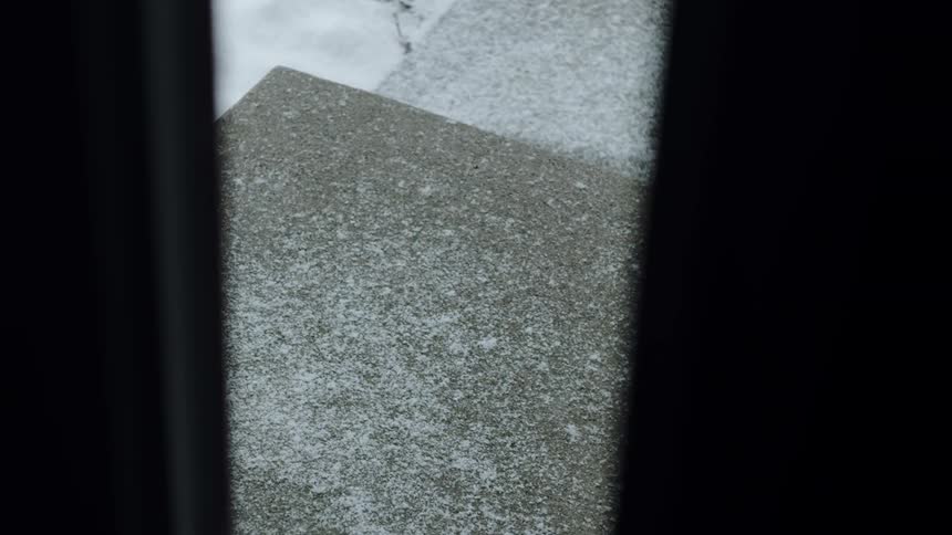 A close up shot of snow falling onto pavement