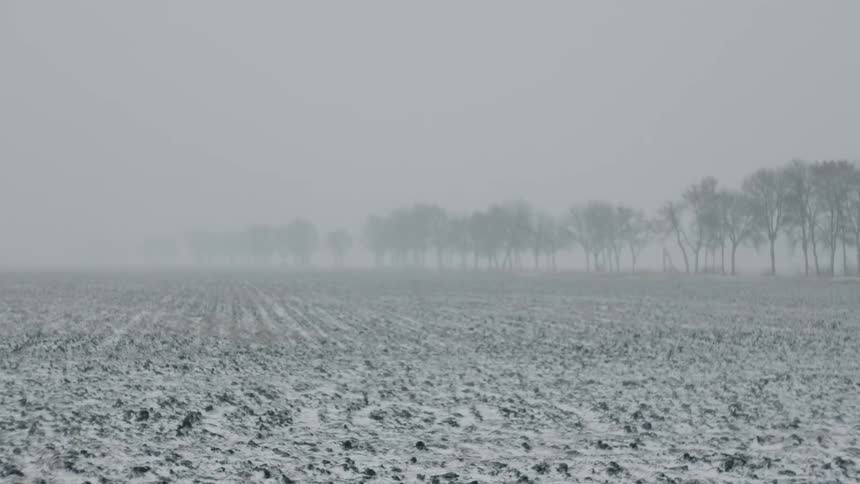 A plot of farmland lies partially buried in snow