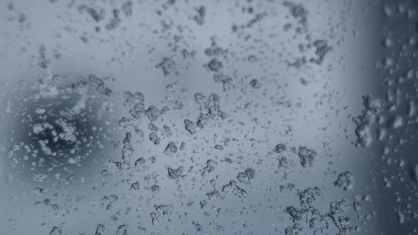 Sleet and ice falling onto a window