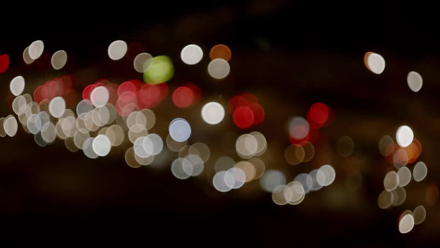 The camera blurry watches cars drive down a highway