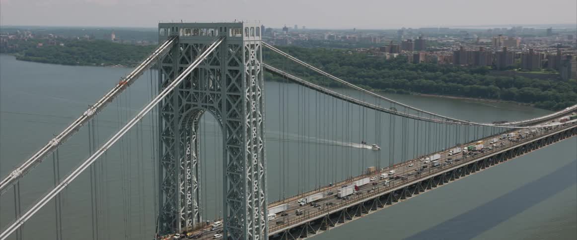 An aerial shot of a bridge by a forest