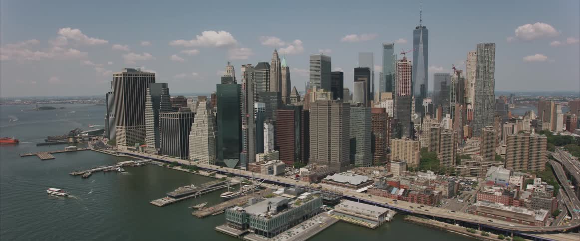 Skyline of the city with tall skyscrapers while vehicles drive on the highway in the daytime