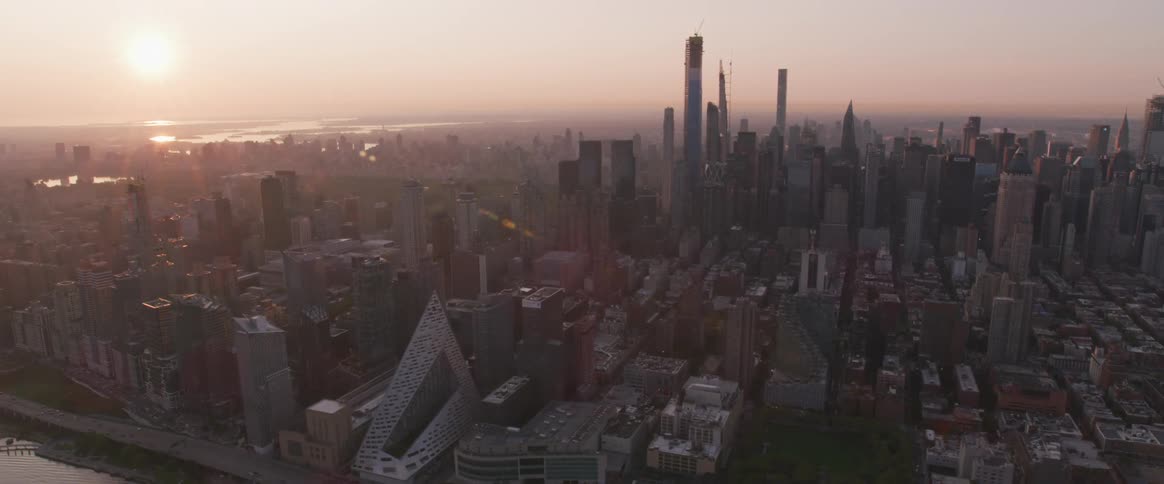 Cityscape with sun rising on the horizon amid haze