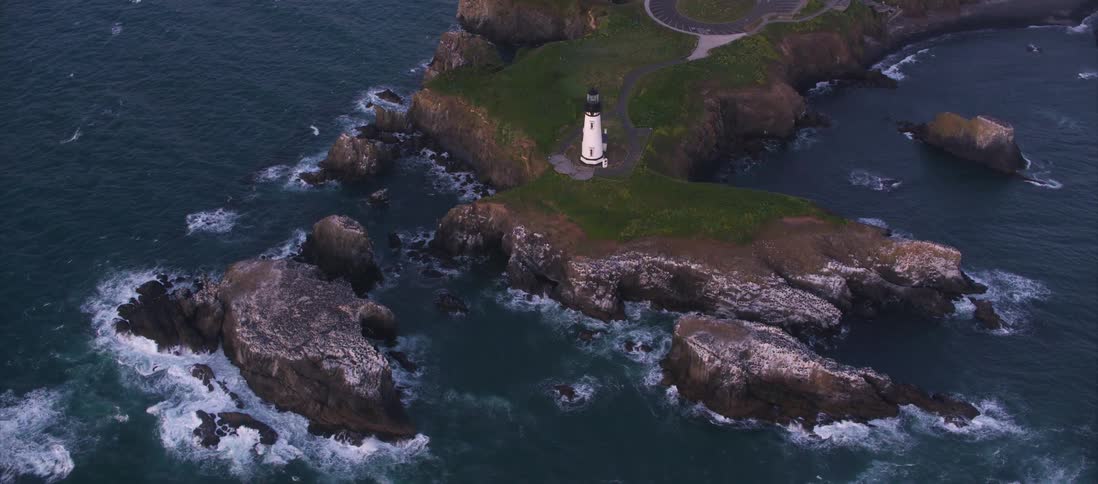 A lighthouse on a headland during the day