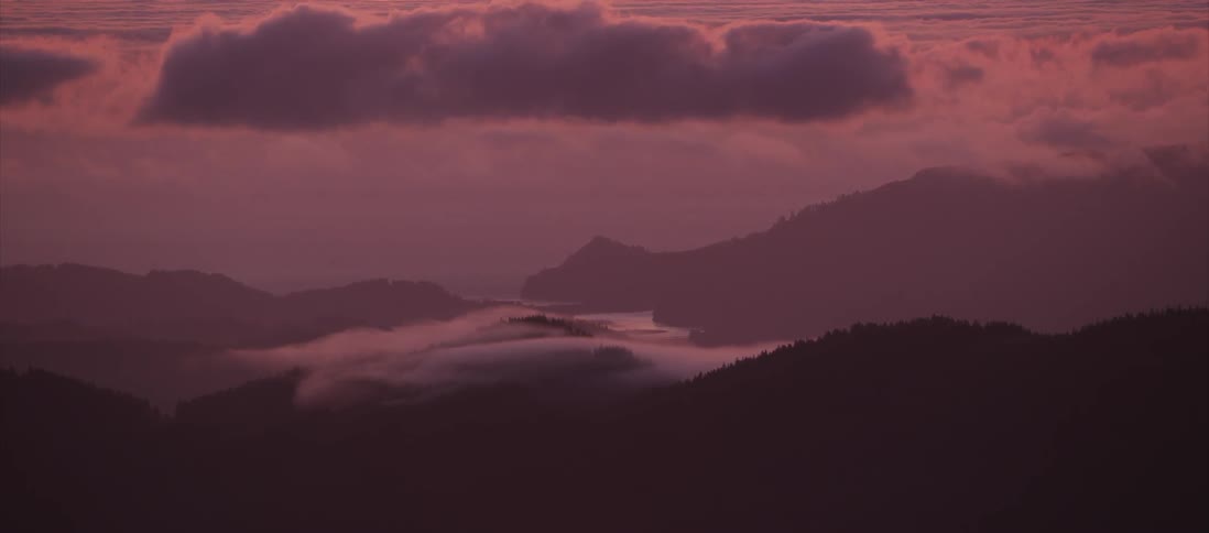 Clouds over a hilly landscape at sunset