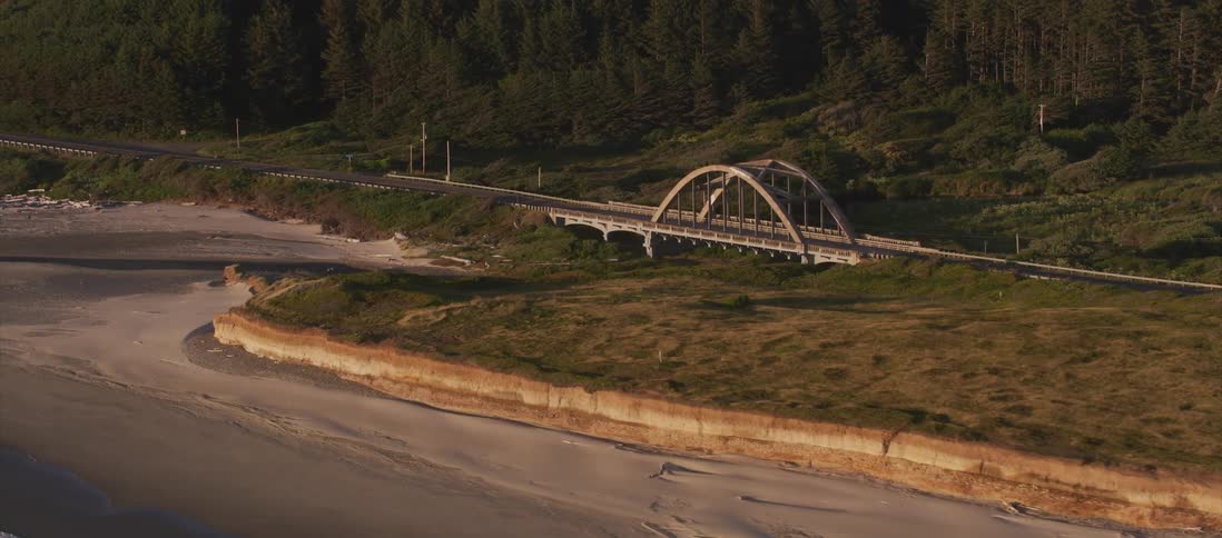An aerial shot of a bridge by the beach