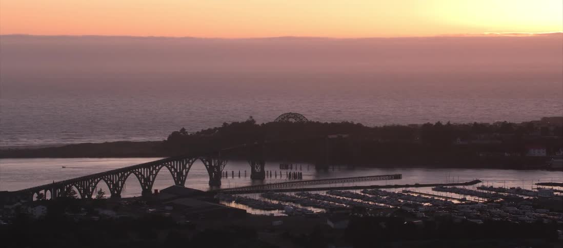 An aerial shot of a bridge by an ocean
